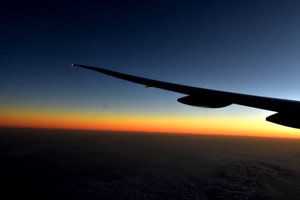 istock Silhouette of Airplan wing in twilight sky, with beautiful light from dramatic sunset, Romantic view from airplane window. 1234991642