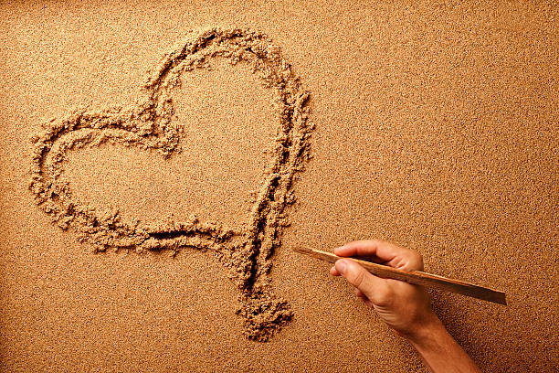 Heart Shape in Sand. A Symbol of Love and Affection on a Sandy Beach Surface.