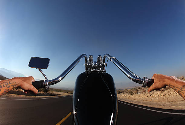 Motorbike rider on the road, reflective view of his face on mirror.