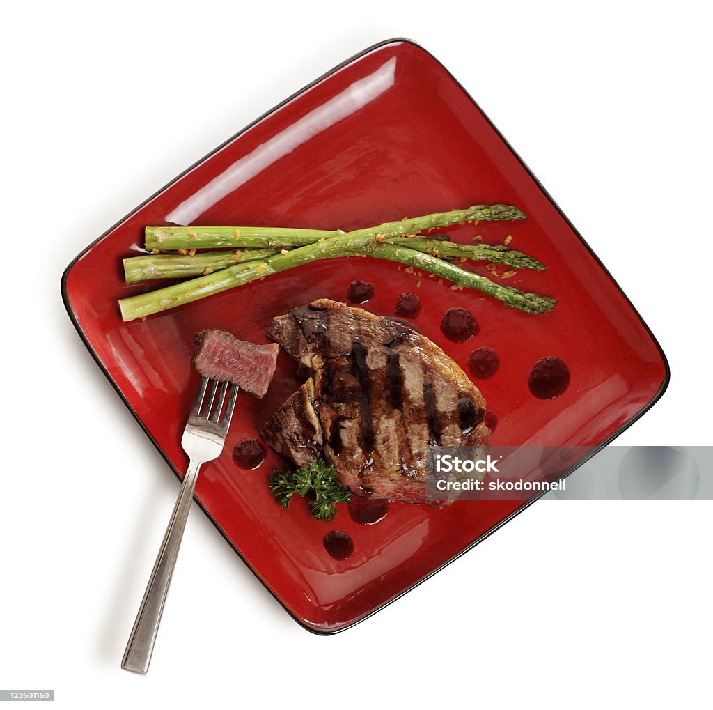 Vista dall'alto di Bistecca di manzo su un piatto rosso - Foto stock royalty-free di Bistecca di manzo