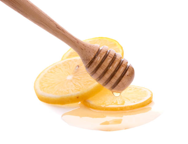 istock Lemon and wooden honey dipper isolated on white background 1235018432