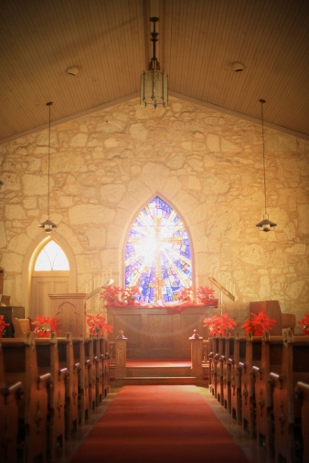 A backlit stained glass window inside of a small-community church in San Antonio, Texas.
