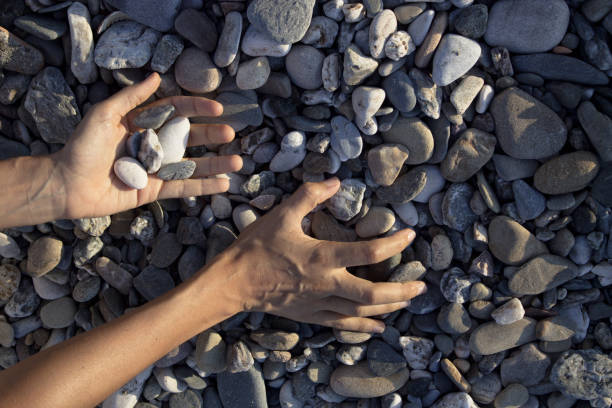 istock Woman hands touching stones on the beach. Grey stones 1235063170