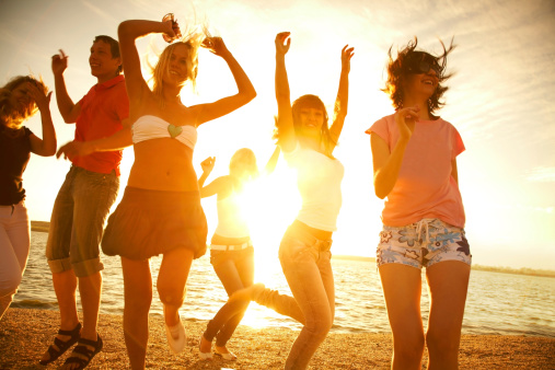 Photo of a group of smiling and cheerful young women spending their summer vacation by the sea
