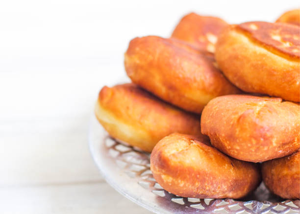 istock Piroshki - russian baked puff pastry with cabbage fillings. Traditional russian cabbage stuffed baked pastry. lean pies with cabbage. Beautiful homemade cakes with cabbage in metal dishes on white 1235075607