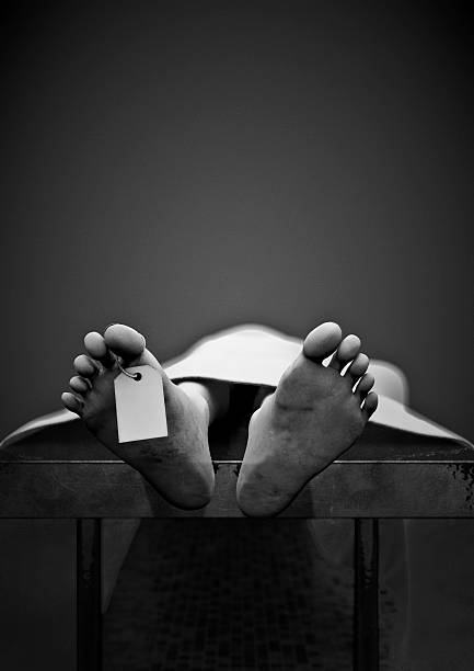 Black and white photo of a dead man's feet with toe tag stock photo