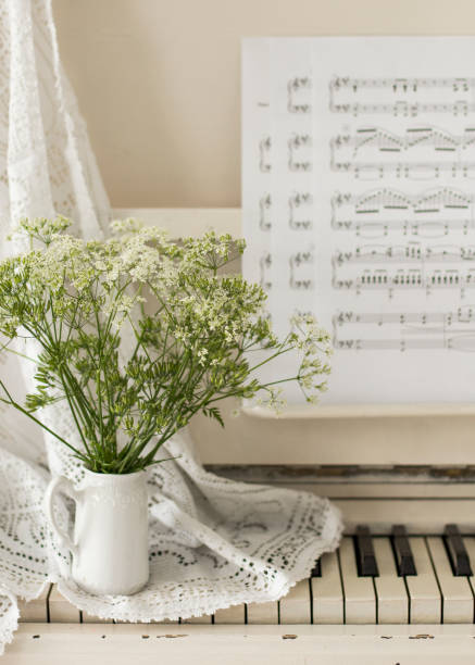 istock bouquet wildflowers on white piano with notes. Retro photo 1235083851