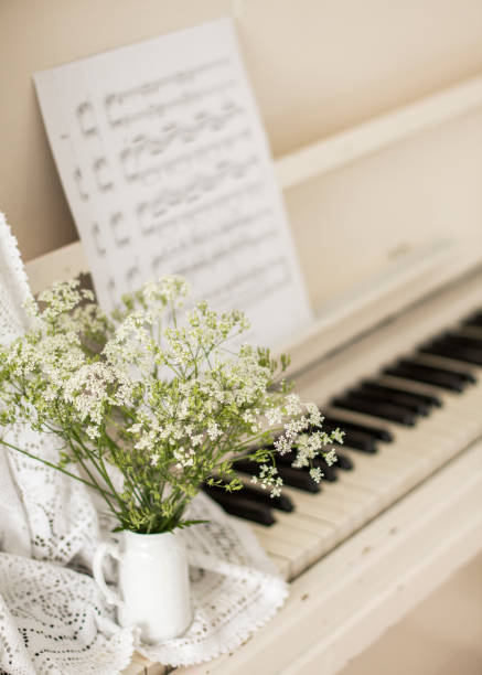 istock bouquet wildflowers on white piano with notes. Retro photo 1235083852