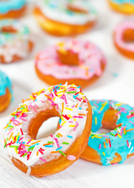 istock Colorful Donuts turquoise and pink on White Background close-up. Doughnuts with multi colored glaze. Doughnuts are traditional sweet pastries. beautiful and bright pastries 1235090516
