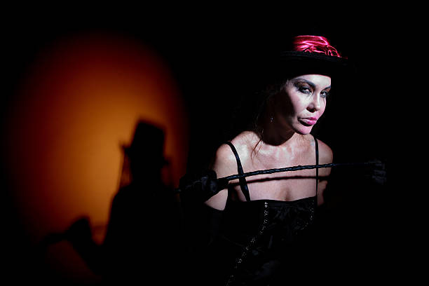 Lady in black carries whip Pale looking woman dressed in black with whip Tied Up Bondage Women Fetish Wear stock pictures, royalty-free photos & images