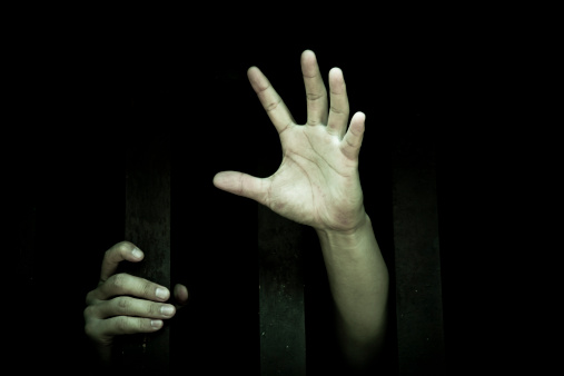 human hand stretch out  from prison bars