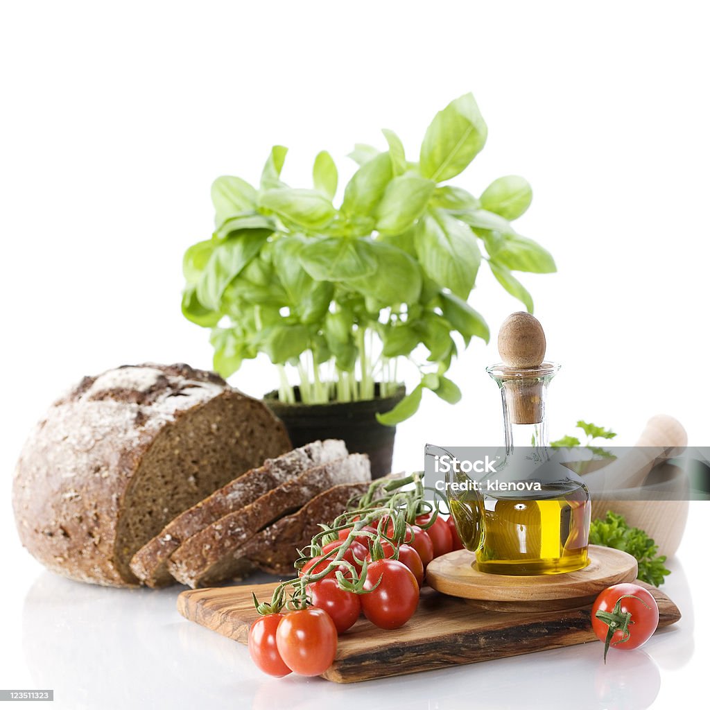Bread, herbs, olive oil and vegetables Bread, herbs, olive oil and vegetables over white Basil Stock Photo