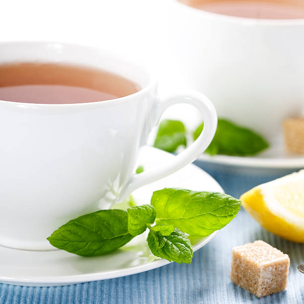 fresh herbal mint tea herbal tea, mint and lemon on blue napkin sooth stock pictures, royalty-free photos & images