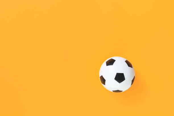istock Soccer ball on yellow background 1235158745