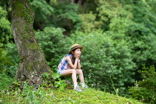 Girl sitting on a tree trunk in the forest