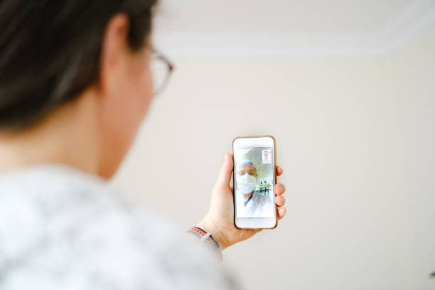 istock young woman using smartphone and having video call with doctor 1235192970