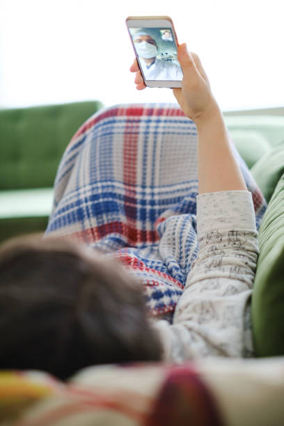 istock young woman using smartphone and having video call with doctor 1235195067