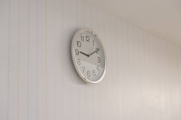 silver and white clock on white wall. metal clock wall in baby room.
