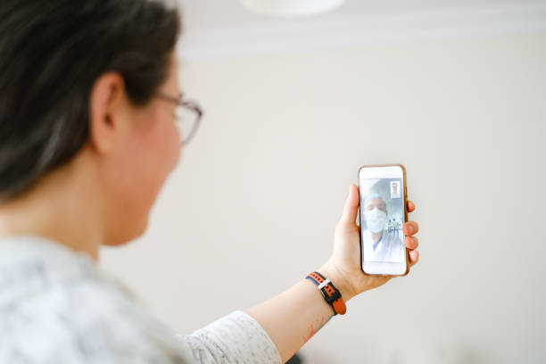 istock young woman using smartphone and having video call with doctor 1235196610