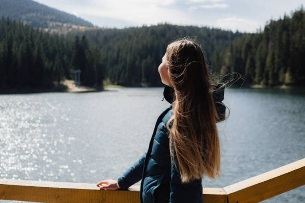 istock Young wman is looking on the lake in mountains 1235200872