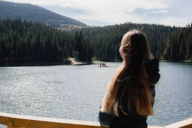 istock Young wman is looking on the lake in mountains 1235203357