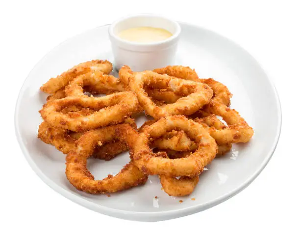 Squid rings, deep fried with sauce on white background