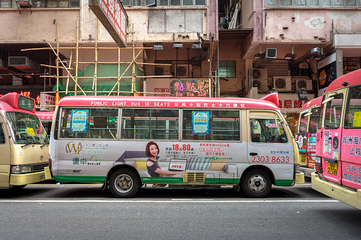 Mongkok / Hong Kong - January 2019 : Minibus parking on the street in rush hour (very busy), waiting for passenger, is the most famous signature of Hong Kong public transportation.
