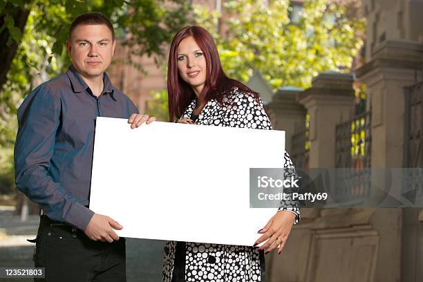 Photo libre de droit de Jeune Couple Avec Tableau Blanc banque d'images et plus d'images libres de droit de Adulte - Adulte, Affiche, Arbre