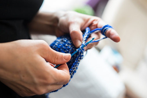 a woman knitting blue bag handmade craft