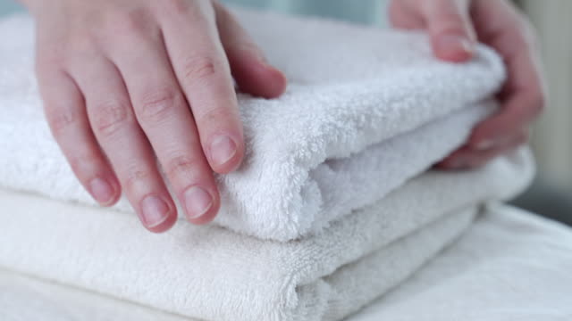 A woman touches a fresh white towel