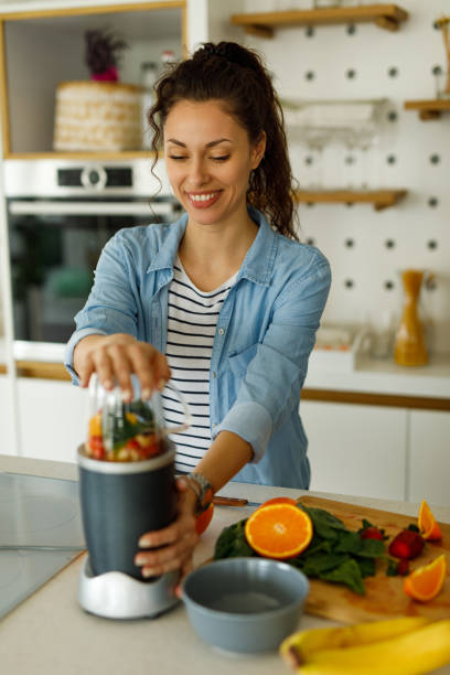 istock Young woman preparing smoothie at home 1235245271