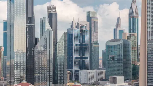 Aerial view on downtown and financial district in Dubai timelapse, United Arab Emirates with skyscrapers and highways. Cloudy sky