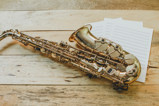 saxophone with music sheet note on wooden background covered by oil color can be use for music background can be use for music background