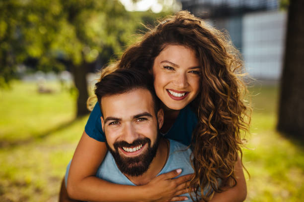 istock Man giving his pretty girlfriend a piggy back 1235251014