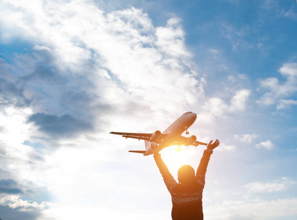 istock Boy arms raised and waving to the airplane 1235388507
