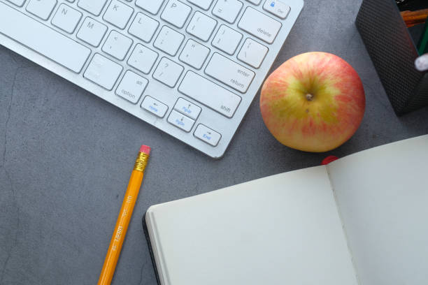 istock Top view of open booms, apple and keyboard on gray background 1235409100