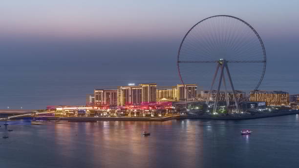 Bluewaters Island in Dubai aerial day to night timelapse after sunset Bluewaters Island in Dubai aerial day to night transition timelapse after sunset. Man-made mixed use island located off the coast of Jumeirah Beach Residence dubai island stock pictures, royalty-free photos & images