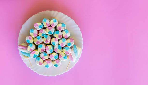 istock plate with colorful Marshmallows, pink background 1235494416