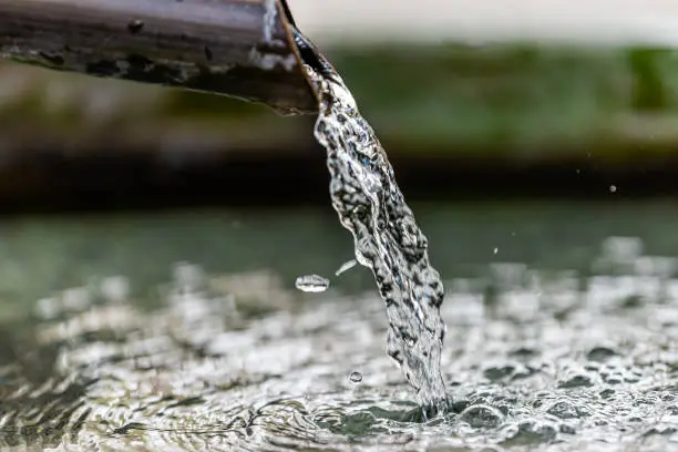 Photo of Purification water fountain in Kyoto, Japan with liquid running from spout faucet closeup