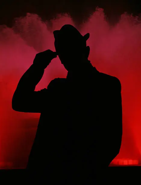Man's silhouette on red fountain.
