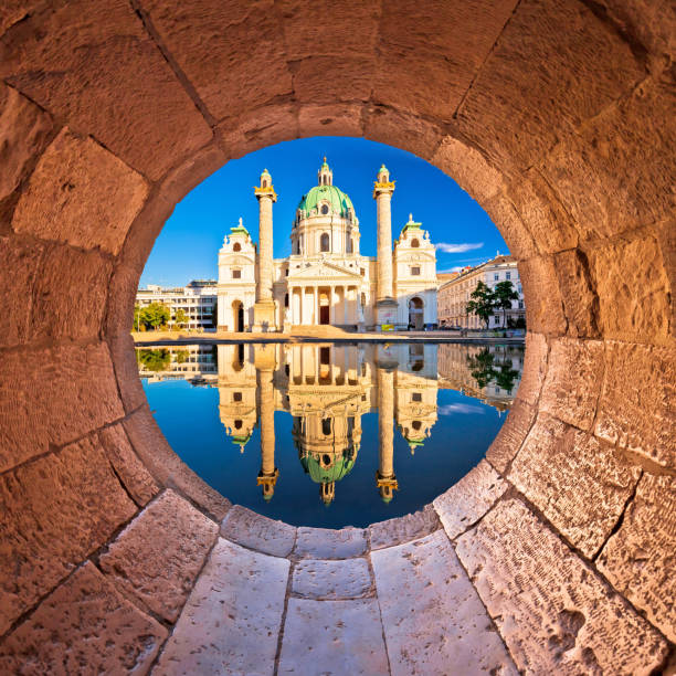 vienna. vista a riflessione della chiesa di karlskirche di vienna attraverso la finestra di pietra - karlsplatz foto e immagini stock