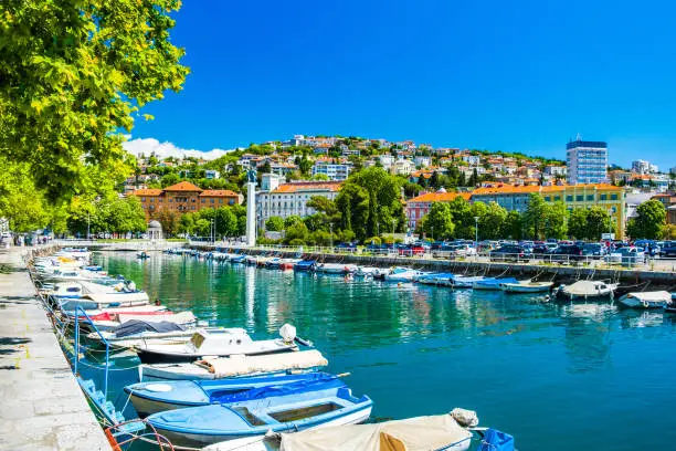 Croatia, city of Rijeka, skyline view from Delta and Rjecina river over the boats in front, colorful old buildings, monuments and Trsat on the hill in background