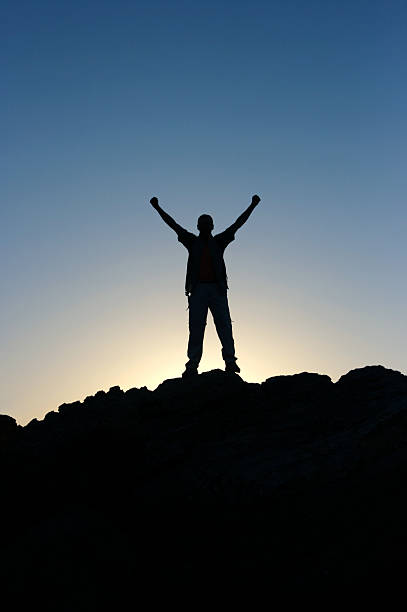 istock Man silhouette standing on top of mountain 123556209