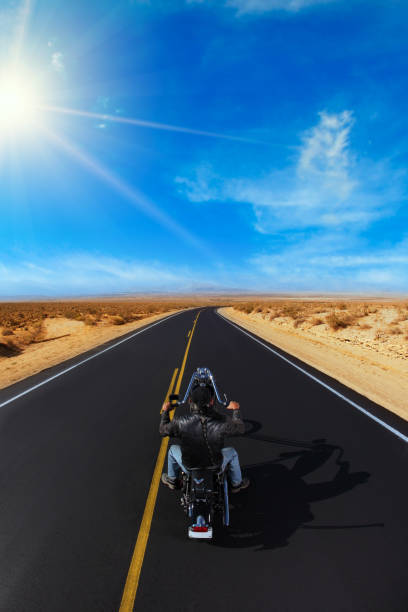 istock Biker in the Desert Riding Off 1235562246