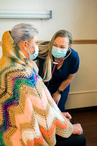 istock Nurse listening to a patient's lungs 1235567453