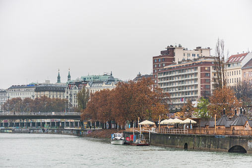 Landscape with buildings and skylines at the riverbank of Donaukanal (Danube cannal)  in a rainy day,  , in Vienna, Austria.