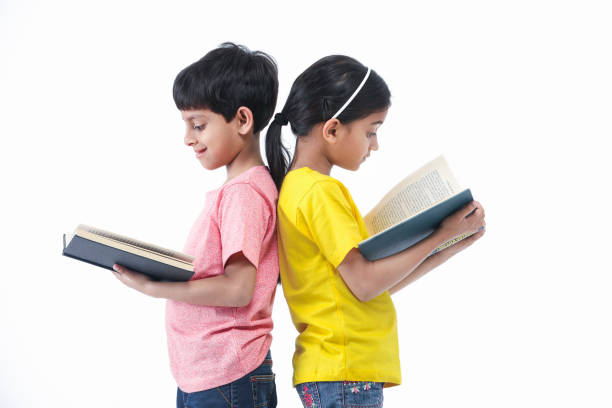 istock Girl and Boy reading book with back facing each other 1235606850