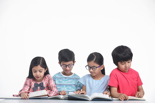 Indian Children girls and boys Sitting and reading books, group study stock photo