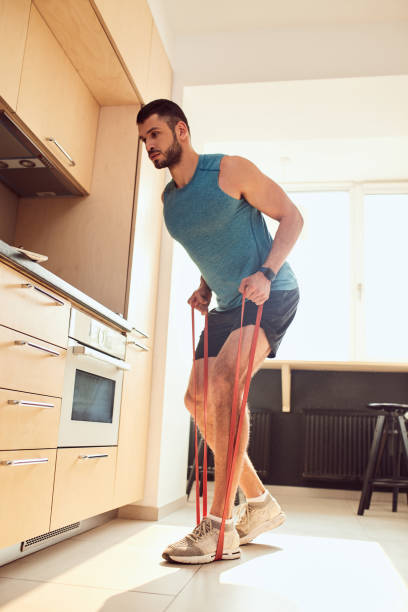 Handsome gentleman doing exercise with elastic fitness band