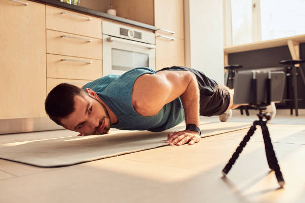 istock Handsome young man doing push-ups at home 1235614180